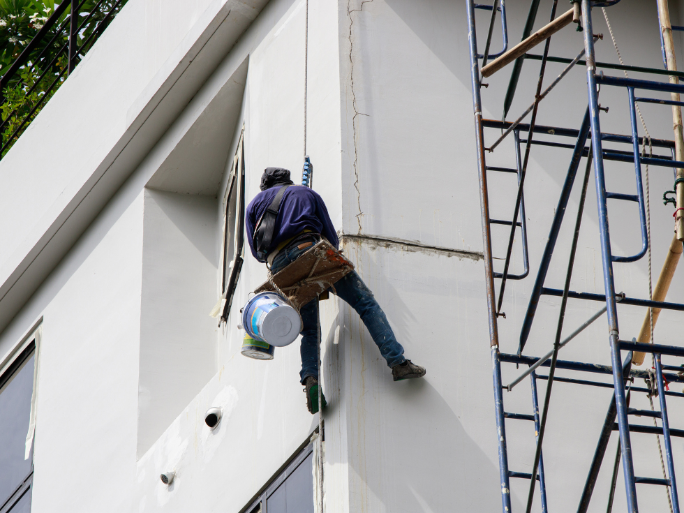 A Painter In Navy Blue Sweatshirt Is Painting A Building - Asian Paints